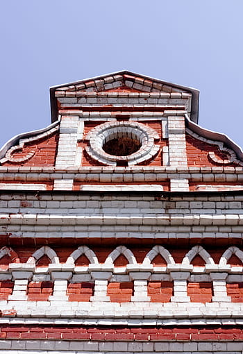 house, sky, brick architecture, circular window, red bricks, white bricks, architectural details, building facade, clear sky, ornate design, historical building