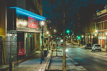 street photography, neon sign, morning, car, road, downtown, sidewalk, street lamp, dark sky, lens flare