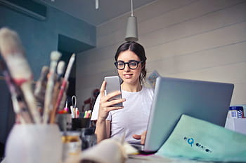 young, woman, glasses, laptop, looks, mobile, phone, happy, looking, pen, sitting