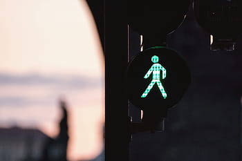 traffic light, green, pedestrian signal, walk sign, street crossing, urban infrastructure, city life, road safety, illuminated sign, evening scene, outdoor setting