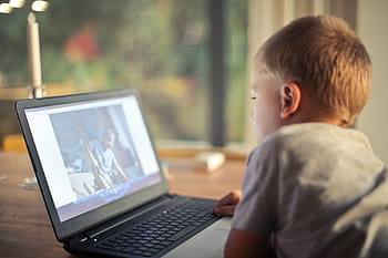 joven, niño caucásico, mirando, película, computadora portátil, sala de estar, solo, niño, poco, música, ver