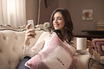 young, woman, looking, mobile, phone, enjoying, coffee, living, room, 25-30 years, couch