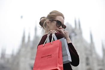 young, blonde, woman, wearing, red, dress, holding, shopping bags, hand, looks, shoulder